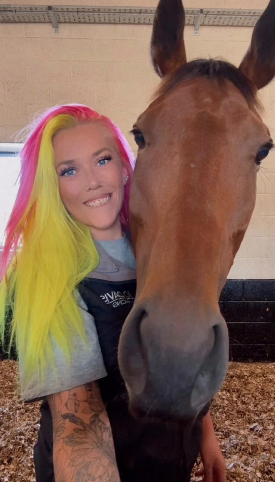 Holly with a bay horse in the stables